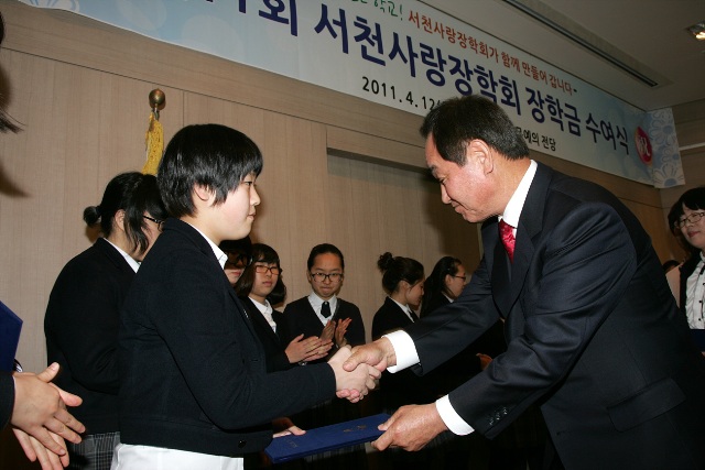 김중원 서천사랑장학회 이사장이 장학생으로 선발된 학생에게 장학금을 전달하고 있다